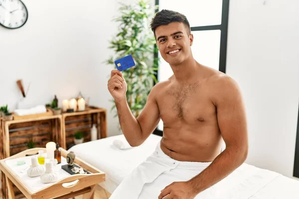Young Hispanic Man Smiling Confident Holding Credit Card Beauty Center — Stok fotoğraf