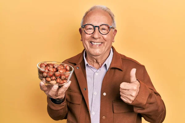 Hombre Mayor Con Pelo Gris Sosteniendo Avellanas Sonriendo Feliz Positivo —  Fotos de Stock