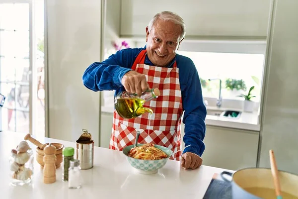 Senior Man Smiling Confident Pouring Oil Spaghetti Kitchen — Stock Photo, Image