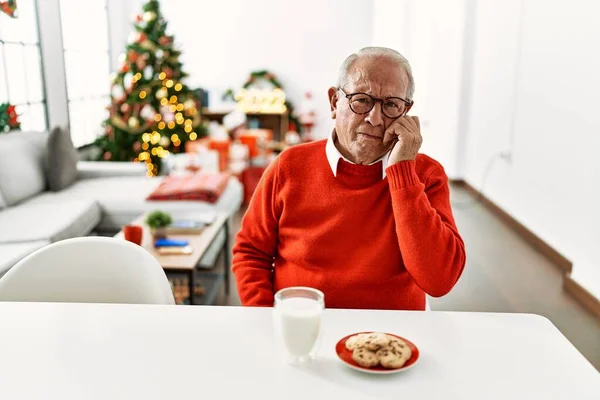 Starší Muž Šedivými Vlasy Sedí Stole Sušenkami Vánočního Stromku Vypadá — Stock fotografie