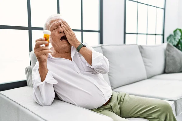 Starší Muž Držící Pilulky Unaveně Zírající Zakrývající Půlku Obličeje Oči — Stock fotografie