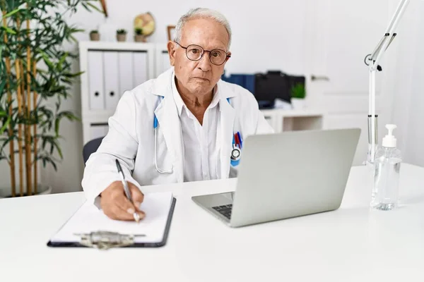 Doktor Üniforması Giyen Kıdemli Bir Adam Klinikte Çalışan Belgeleri Yazıyor — Stok fotoğraf