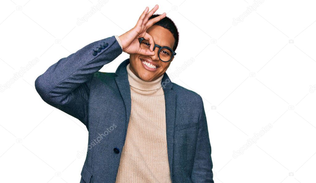Young handsome hispanic man wearing business jacket and glasses smiling happy doing ok sign with hand on eye looking through fingers 