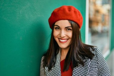 Genç İspanyol kadın gülümseyerek şehirde mutlu mesut dikiliyor..