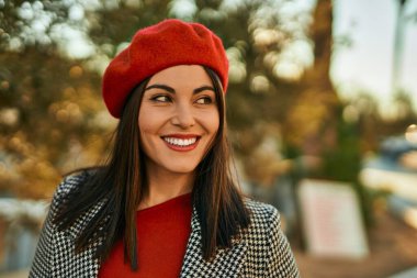 Genç İspanyol kadın gülümseyerek şehirde mutlu mesut dikiliyor..