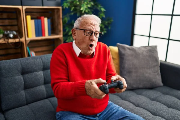 Starszy Mężczyzna Gra Gry Wideo Siedzi Kanapie Domu — Zdjęcie stockowe