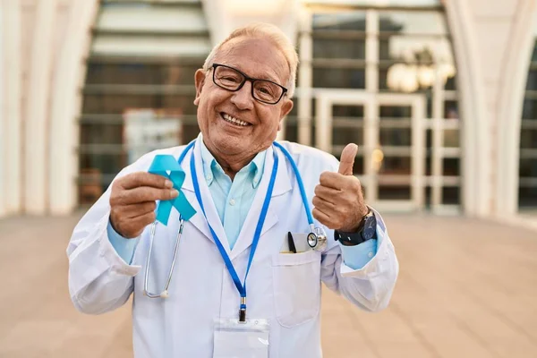 Starší Lékař Šedými Vlasy Drží Modrou Stuhu Úsměvem Šťastný Pozitivní — Stock fotografie