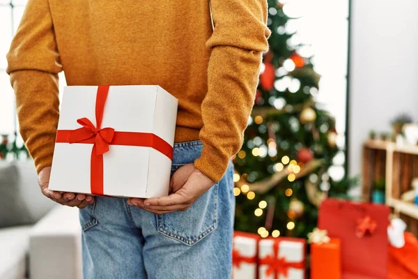 Man Holding Gift His Back Standing Christmas Tree Home — Fotografia de Stock
