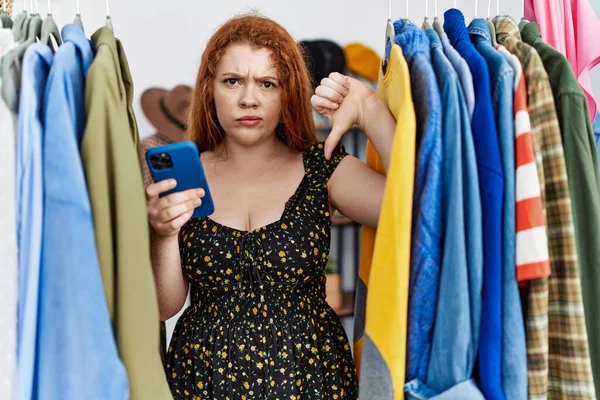 Young Redhead Woman Searching Clothes Clothing Rack Using Smartphone Angry — 图库照片