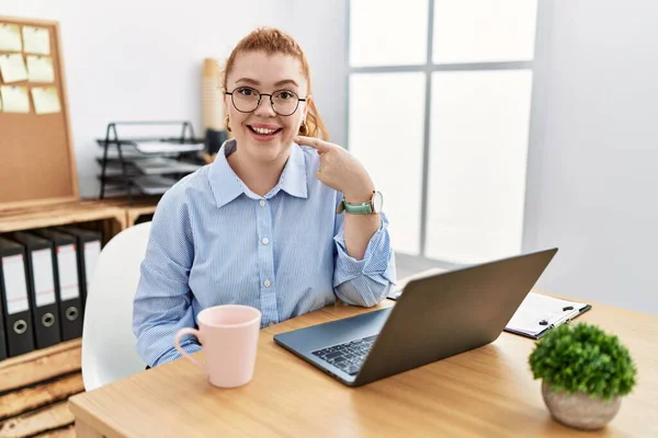 사무실에서 일하는 여자가 컴퓨터 랩탑을 사용하여 손가락으로 가리키며 미소를 있습니다 — 스톡 사진