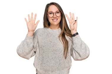 Gündelik süveter giyen ve gözlük takan genç sarışın kadın dokuz numaralı parmaklarını gösterip işaret ederken kendinden emin ve mutlu bir şekilde gülümsüyor.. 