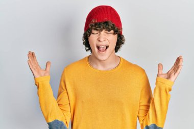 Yün şapka takan yakışıklı genç adam başarının çılgınlığını kutluyor. Kolları havada ve gözleri kapalı heyecanla bağırıyor. Kazanan konsept 