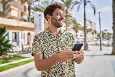 Sokakta akıllı telefon kullanan, kendine güvenen genç bir İspanyol.