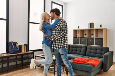 Gülümseyen genç çift evde mutlu dans ediyor..