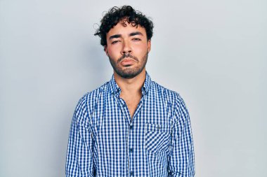 Günlük giysiler giyen genç İspanyol bir adam depresyonda ve sıkıntıdan endişe ediyor, kızgın ve korkmuş bir şekilde ağlıyor. hüzünlü ifade. 