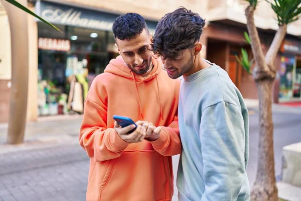 两个男人在街上用智能手机互相拥抱 — 图库照片