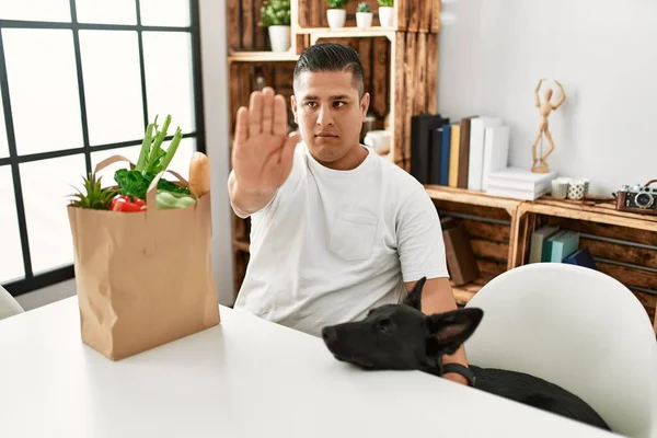 Jovem Hispânico Sentado Com Saco Papel Com Mantimentos Com Mão — Fotografia de Stock