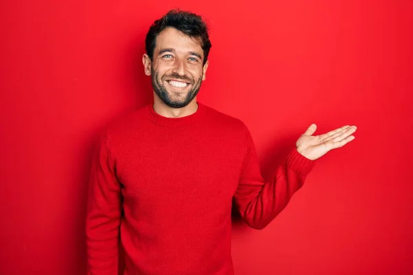 Handsome Man Beard Wearing Casual Red Sweater Smiling Cheerful Presenting — Stockfoto