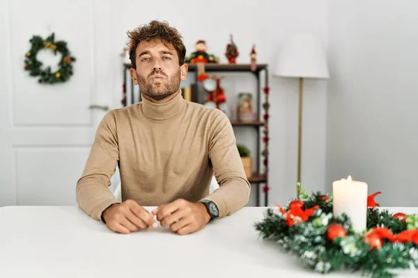 Young Handsome Man Beard Sitting Table Christmas Decoration Looking Camera — Fotografia de Stock