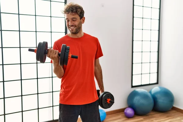 Giovane Uomo Ispanico Sorridente Allenamento Fiducioso Utilizzando Manubri Centro Sportivo — Foto Stock