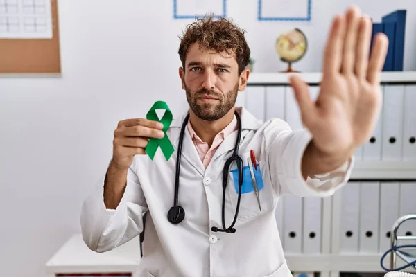 Young Hispanic Doctor Man Holding Support Green Ribbon Clinic Open — Stok fotoğraf