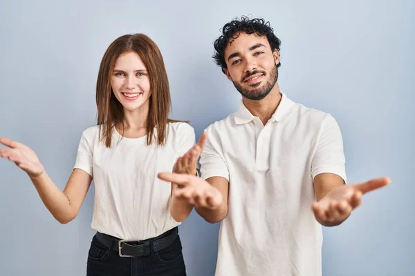 Young Couple Wearing Casual Clothes Standing Together Smiling Cheerful Offering — Φωτογραφία Αρχείου