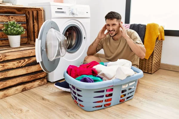 Young Handsome Man Putting Dirty Laundry Washing Machine Covering Ears — 图库照片