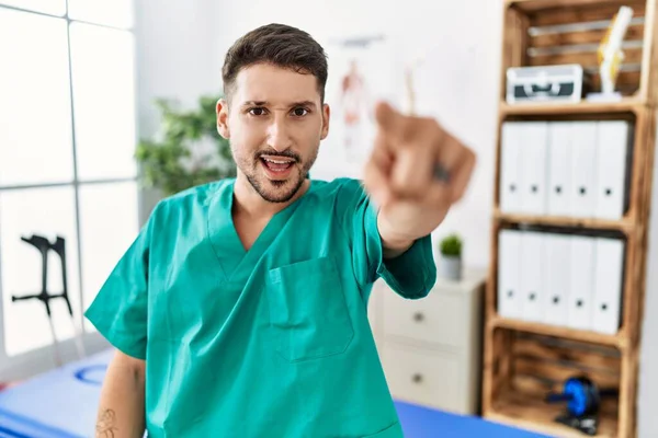 Young Physiotherapist Man Working Pain Recovery Clinic Pointing Displeased Frustrated — Fotografia de Stock