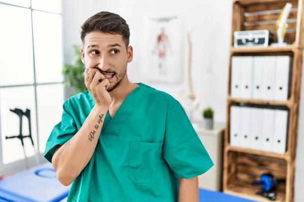 Young Physiotherapist Man Working Pain Recovery Clinic Looking Stressed Nervous — Stockfoto