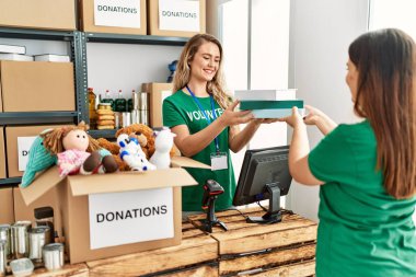 Genç gönüllü kız yardım merkezinde kadına yardım ediyor..