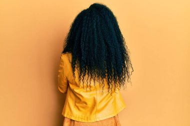 Middle age african american woman wearing wool winter sweater and leather jacket standing backwards looking away with crossed arms 