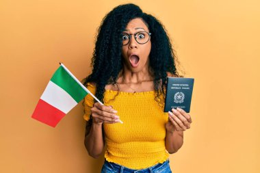 Orta yaşlı Afro-Amerikan kadını elinde İtalyan bayrağı ve pasaportu tutarken şaşkınlık ve şaşkınlık içinde bir ifade, korku ve heyecan dolu bir yüz vardı.. 
