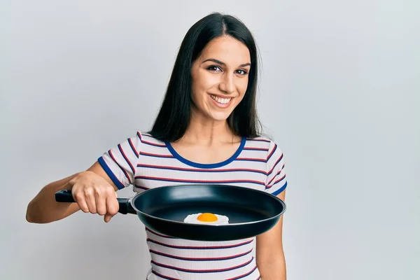 Young Hispanic Woman Holding Billet Fried Egg Looking Positive Happy — Stock Photo, Image