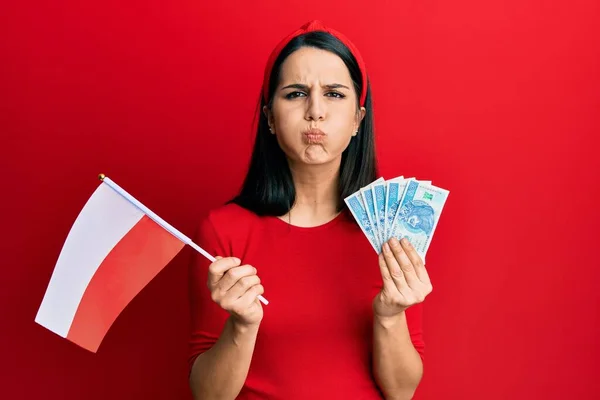 Young Hispanic Woman Holding Poland Flag Zloty Banknotes Puffing Cheeks — 图库照片