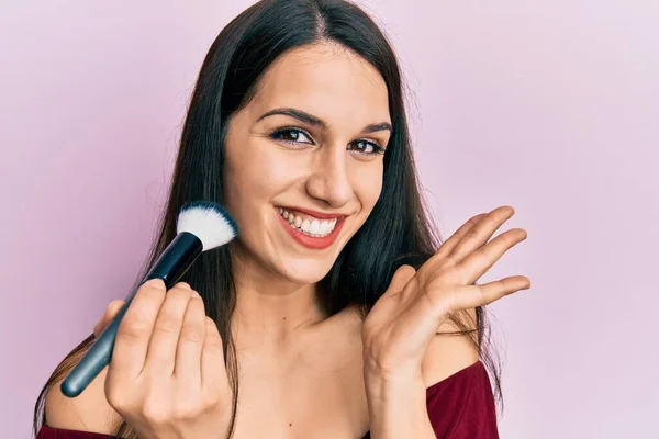 Young Hispanic Woman Holding Makeup Brush Blush Celebrating Achievement Happy — 스톡 사진