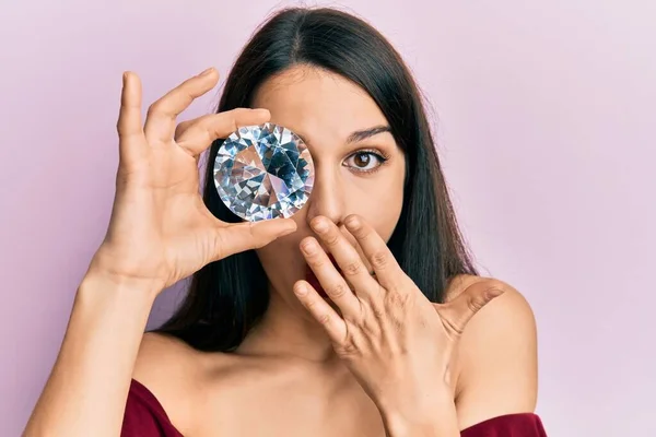 若いヒスパニック系の女性の手で口をカバーし ショックを受け ミスを恐れて目に鮮やかなダイヤモンドの石を保持 驚きの表情 — ストック写真
