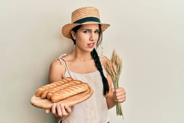 Young Hispanic Woman Holding Homemade Bread Spike Wheat Clueless Confused — Stock Fotó