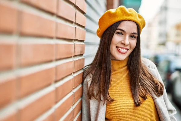 Genç İspanyol kız gülümseyerek şehirde mutlu mesut dikiliyor..