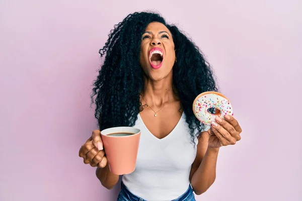 Középkorú Afro Amerikai Fánkot Eszik Kávét Iszik Dühös Őrült Sikoltozva — Stock Fotó