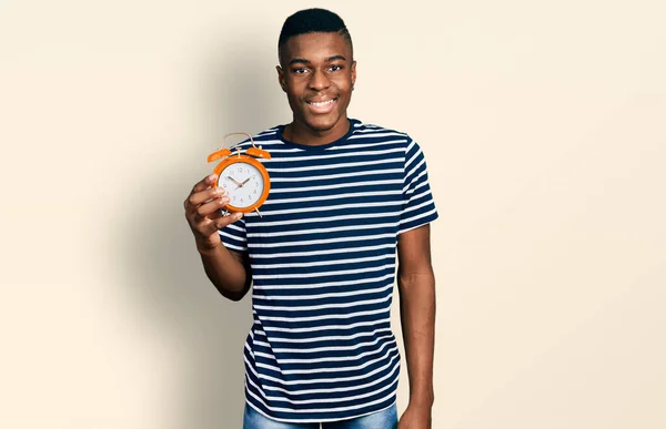 Young African American Man Holding Alarm Clock Looking Positive Happy — Stock Photo, Image