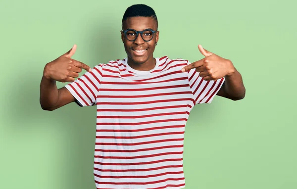 年轻的非洲裔美国人 身穿休闲装 戴着眼镜 脸上挂着微笑 用手指指着自己 自豪而快乐 — 图库照片