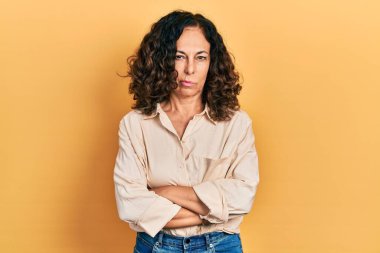 Orta yaşlı İspanyol kadın gündelik kıyafetler giyiyor. Kuşkucu ve gergin. Yüzünde çapraz kollu tasvip etmeyen bir ifade. negatif kişi. 