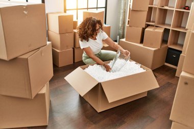 Orta yaşlı İspanyol kadın gülümsüyor kendine güvenen yeni evine taşınıyor