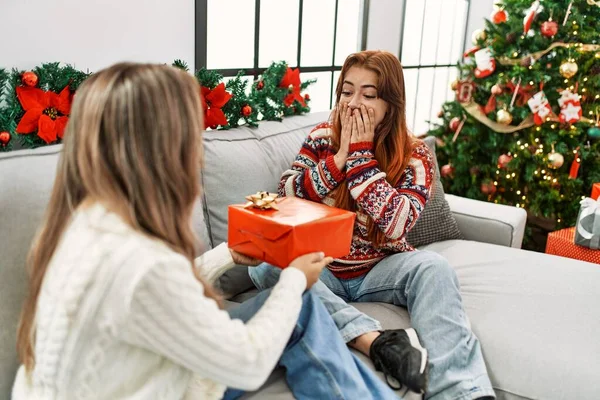 女人在家里坐在圣诞树旁 带着礼物感到惊奇 — 图库照片
