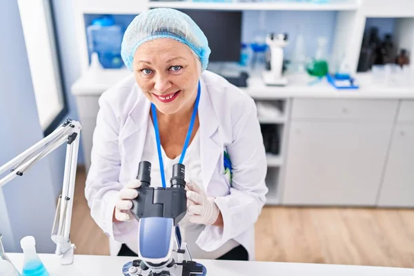 Medelålders Blond Kvinna Bär Forskare Uniform Med Hjälp Mikroskop Laboratoriet — Stockfoto