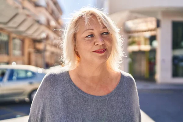 Sokakta duran orta yaşlı sarışın kadın.