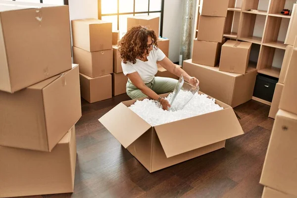 Orta yaşlı İspanyol kadın gülümsüyor kendine güvenen yeni evine taşınıyor