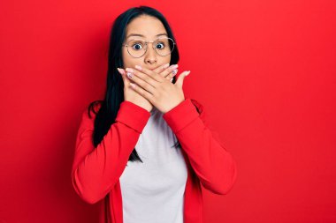 Burnunda piercing olan, sıradan bir bakış ve gözlük takan, ağzı yanlışlıkla ellerle kapatan güzel İspanyol bir kadın. gizli kavram. 