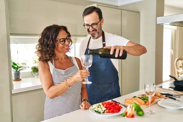 Middle Age Hispanic Couple Cooking Pouring Wine Glass Kitchen —  Fotos de Stock