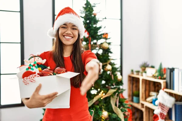 Mulher Morena Jovem Junto Árvore Natal Segurando Decoração Sorrindo Oferta — Fotografia de Stock